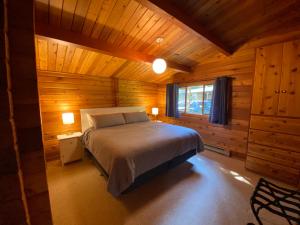 a bedroom with a bed in a wooden cabin at April Point Harbour House in Quathiaski Cove