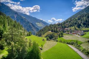 ein grünes Tal mit einem Dorf in den Bergen in der Unterkunft Residence Schnals in Schnals