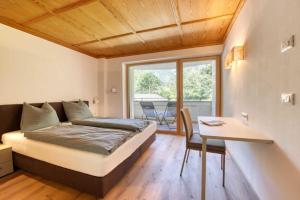 Schlafzimmer mit einem Bett, einem Tisch und einem Fenster in der Unterkunft Residence Schnals in Schnals