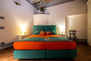 um quarto com uma cama grande com lençóis laranja e verde em IBibiena -SUITE CASA FIORITA em Bibbiena