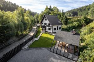 an aerial view of a white house in the woods at Villa Trésor Voronet in Gura Humorului +46 photos