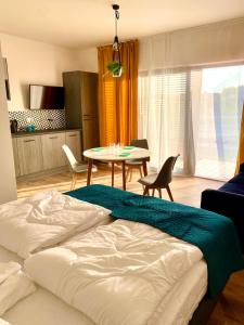 1 dormitorio con 1 cama y 1 mesa con sillas en Apartamenty Czerwone Korale, en Chłopy