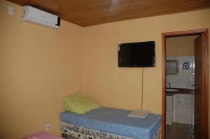 Cette chambre comprend un lit et une télévision murale. dans l'établissement Aguasclaras Residencial, à Manaus