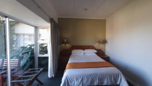 a bedroom with a bed and a large window at Mountain View International by BON Hotels in Mbabane