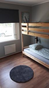 a bedroom with a bunk bed and a rug at Skabram Camping & Stugby in Jokkmokk