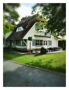 a white house with a thatched roof at Bed & Bokes aan de Maaskant in Lanaken