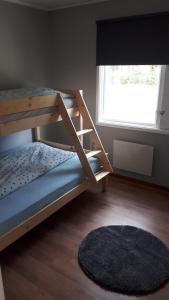 a bedroom with a bunk bed and a window at Skabram Camping & Stugby in Jokkmokk