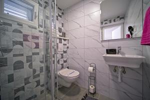a bathroom with a toilet and a sink at Apartments Lux in Makarska