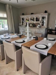 une salle à manger avec une grande table en bois et des chaises dans l'établissement Bed & Bokes aan de Maaskant, à Lanaken