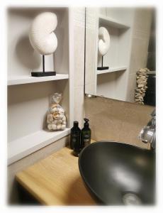 W łazience znajduje się czarna umywalka i lustro. w obiekcie Bed & Bokes aan de Maaskant w mieście Lanaken