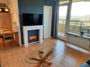 een woonkamer met een open haard en een tv erboven bij Apartment 560 in Hohegeiß
