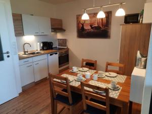 een keuken met een houten tafel met stoelen en een eetkamer bij Apartment 560 in Hohegeiß +12 foto's