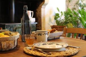 a wooden table with a plate of food and a bottle at Le Domaine du Petit Tertre in Saint-Jean-dʼAssé +19 photos