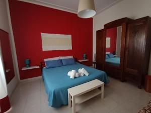 een slaapkamer met een blauw bed en handdoeken bij Hospiton Home in Cagliari