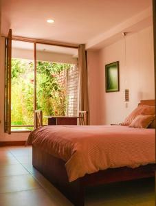 - une chambre avec un lit et une grande fenêtre dans l'établissement Bamboo Village Place, à Tumbaco