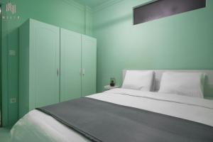 テッサロニキにあるColorful, Nilie Hospitality MGMTのベッドルーム(白いベッド1台、緑のキャビネット付)