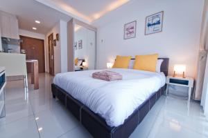 1 dormitorio con 1 cama grande con almohadas amarillas en AMAZING VIEW Studio in Laguna Beach Resort 2., en Jomtien Beach