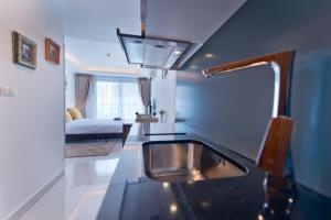 a kitchen with a sink and a bed in a room at AMAZING VIEW Studio in Laguna Beach Resort 2. in Jomtien Beach