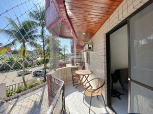 Un balcón de una casa con una mesa y sillas. en APARTAMENTO Pe na Areia com piscina vista mar bairro nobre, en Bertioga