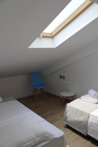 sypialnia z 2 łóżkami i niebieskim krzesłem w obiekcie Urban Chic Apartments Lefkada w mieście Leukada (miasto)