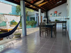 un patio con hamaca, mesa y sillas en Casa Morada do Sol Ubatuba, en Ubatuba