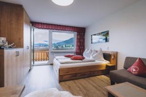 a bedroom with a bed and a large window at Appartement Farina in Kaprun