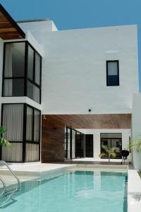 a swimming pool in front of a house at Villa Casa Agua by Sunest in Akumal