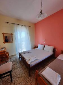 - une chambre avec un grand lit et une chaise dans l'établissement Billy's Amoudi Apartments, à Amoudi