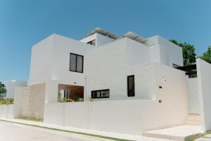 a white house with black windows at Villa Casa Agua by Sunest in Akumal