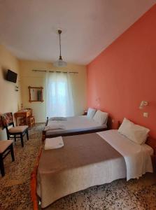 a large bedroom with two beds and a window at Billy's Amoudi Apartments in Amoudi