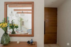 a hallway with a mirror and a table with flowers at Villa Casa Agua in Akumal