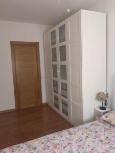 a bedroom with a large white cabinet and a bed at ARAL Apartamento in Alquézar