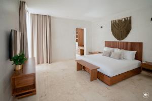 a bedroom with a large white bed and a table at Villa Casa Agua by Sunest in Akumal