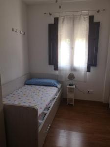 a small bedroom with a bed and a window at ARAL Apartamento in Alquézar