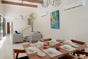 a dining room with a wooden table with chairs and a dining room at Villa Casa Agua in Akumal