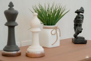 a table with two chess pieces and a vase with a plant at Villa Casa Agua in Akumal