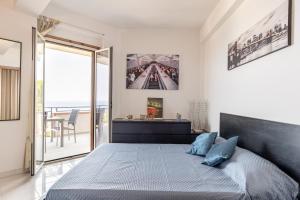1 dormitorio con 1 cama grande y balcón en Casa Azzurra - Sea View Apartment, en Letojanni