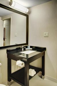 La salle de bains est pourvue d'un lavabo et d'un grand miroir. dans l'établissement Comfort Inn Sherbrooke, à Sherbrooke