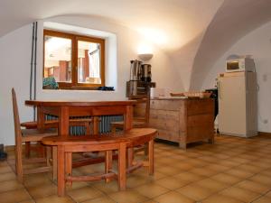 ein Wohnzimmer mit einem Tisch und einem Kühlschrank in der Unterkunft Chalet le Genepy with amazing views! in Molines-en-Queyras