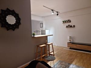 a living room with two stools and a mirror at AryaHome in Bistriţa +6 photos