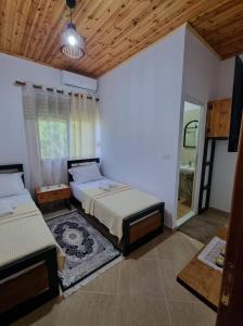 ein großes Schlafzimmer mit 2 Betten und einem Spiegel in der Unterkunft B Vishe Guest House in Gjirokastër