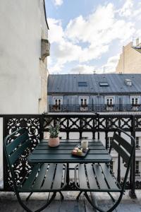 een blauwe tafel en stoelen op een balkon bij O.Lysée Hotel in Parijs