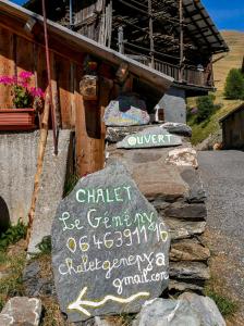 um sinal numa rocha ao lado de um edifício em Chalet le Genepy with amazing views! em Molines-en-Queyras