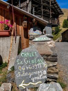 ein Schild auf einem Felsen neben einem Gebäude in der Unterkunft Chalet le Genepy with amazing views! in Molines-en-Queyras