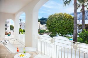 a balcony with white furniture and a view of the city at Pazziella Garden & Suites in Capri