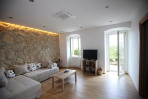 a living room with a couch and a tv at Villa Fani in Rijeka