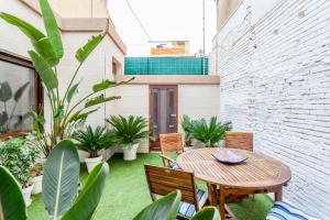 a patio with a table and chairs and plants at CASA ESPECTACULAR DE DISEÑO CON JARDIN INTERIOR in Valencia