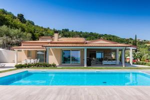 a villa with a swimming pool in front of a house at Villa Lerant in Acquaviva Picena