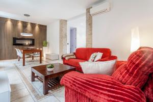 ein Wohnzimmer mit einem roten Sofa und einem Tisch in der Unterkunft CASA ESPECTACULAR DE DISEÑO CON JARDIN INTERIOR in Valencia