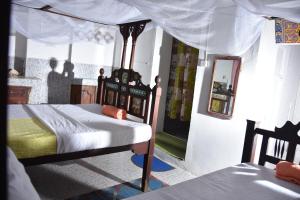 a bedroom with a bed with a canopy at BABAbora house in Ngambo